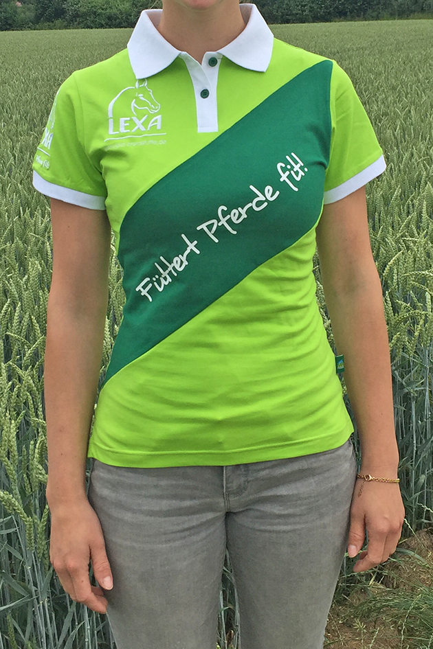 Polohemd mit Slogan Frau trägt ein grünes Polohemd mit weißem Kragen und dem Text 'Füttert Pferde fit!' in geschwungener Schrift.