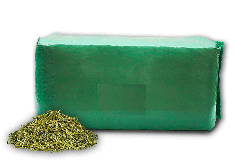 Verpackung mit getrockneten Kräutern Grüne Verpackung mit einem Haufen getrockneter Kräuter daneben.