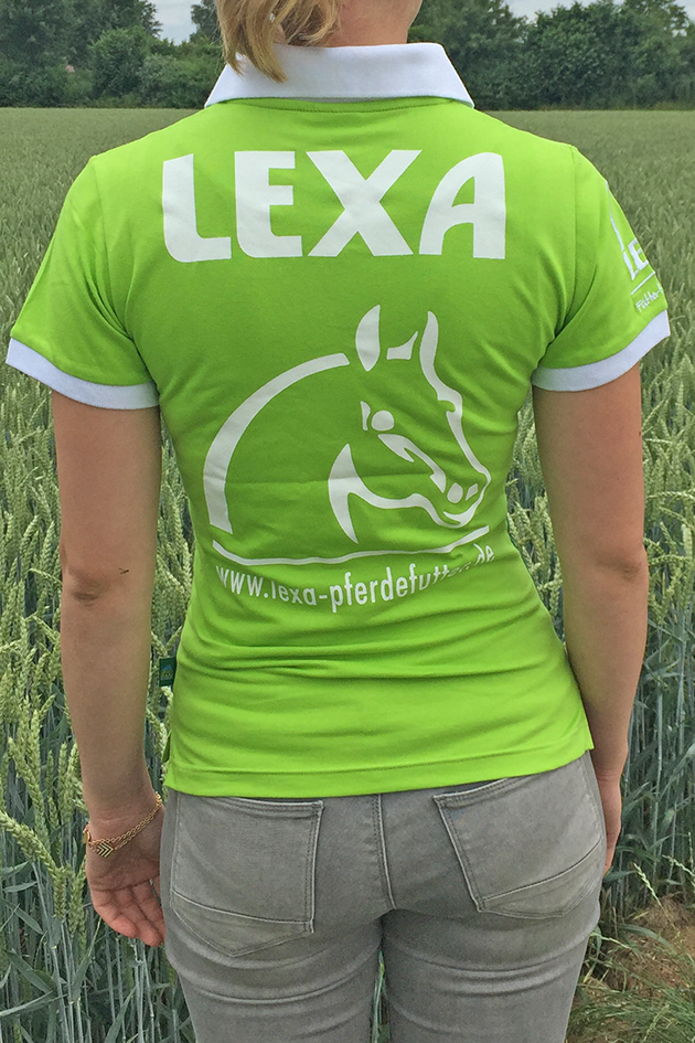 Grünes Poloshirt mit LEXA-Logo Rückansicht einer Person in einem grünen Poloshirt mit dem Aufdruck 'LEXA' und einem Pferdekopf-Logo, vor einem Weizenfeld.